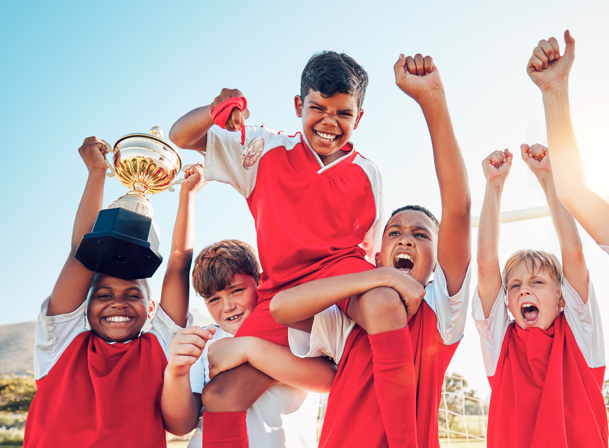 Soccer, celebration and kids team with trophy on soccer field, happy and excited at winning game. S